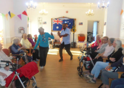 Woodstock Residential Care Home residents sitting in their lounge enjoying a performance by musician Rob T