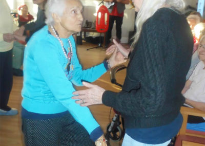 Woodstock Residential Care Home lady residents dancing together in their lounge enjoying a performance by musician Rob T