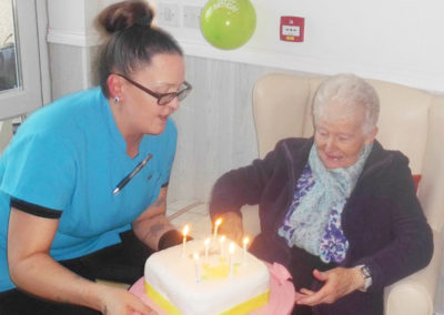 Resident at Woodstock Residential Care Home receiving a birthday cake