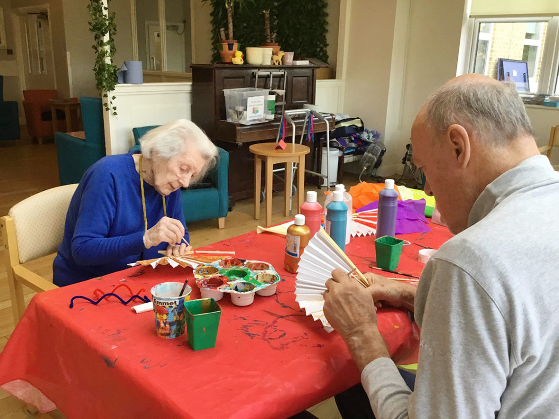 Two residents at Bromley Park sat at a table creating some Chinese New Year arts and crafts