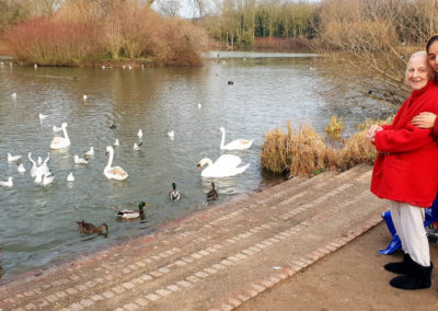 Lady resident of Lukestone Care Home watching the birds on a lake at Capstone Farm Country Park in Chatham