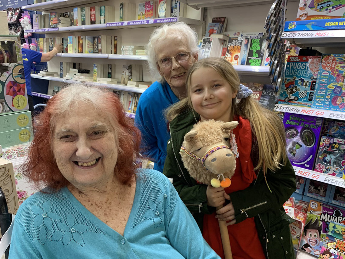 Two residents and a young relative posing for a photo in a gift shop
