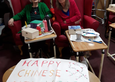 Residents with a Chinese New Year poster at Lulworth House Residential Care Home