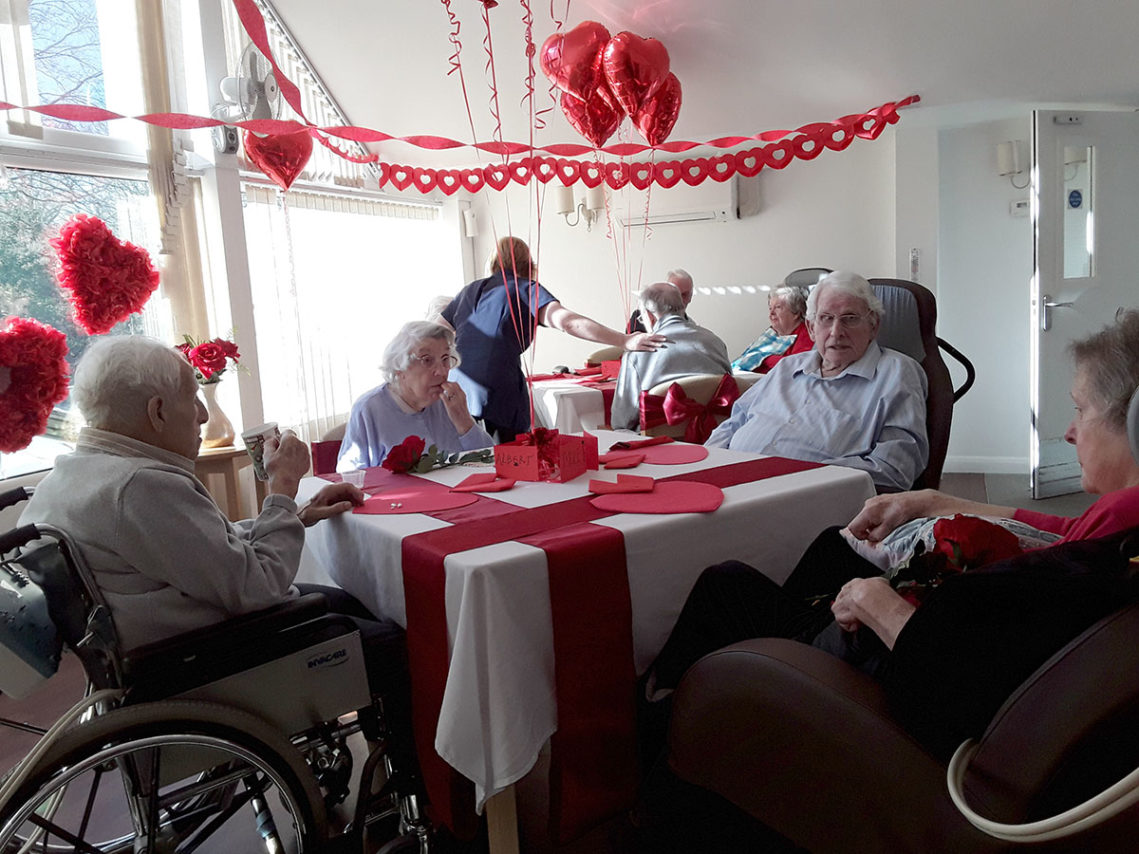 Residents in their dining room which has been decorated for Valentines Day at Abbotsleigh Care Home
