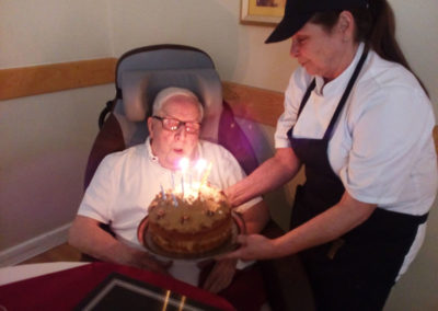 Hengist Field resident Derek blowing out the candle on his birthday cake