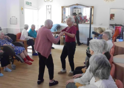 Residents listening to and dancing to musician Rob T in their lounge
