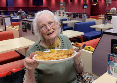 Woodstock lady resident holding up her plate of fish and chips at Buzz Bingo