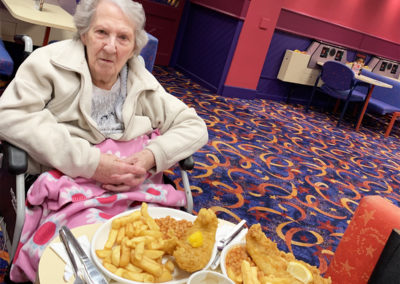 Woodstock lady resident sitting at a table laden with fish and chips at Buzz Bingo
