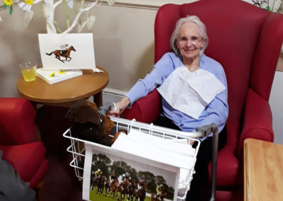 Lady sitting with her mobility aid decorated with a picture of the Grand National