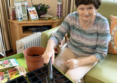 Lady resident potting some seeds inside