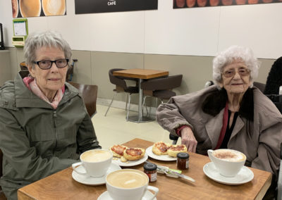 Two lady residents enjoying coffee and scones in an M&S cafe