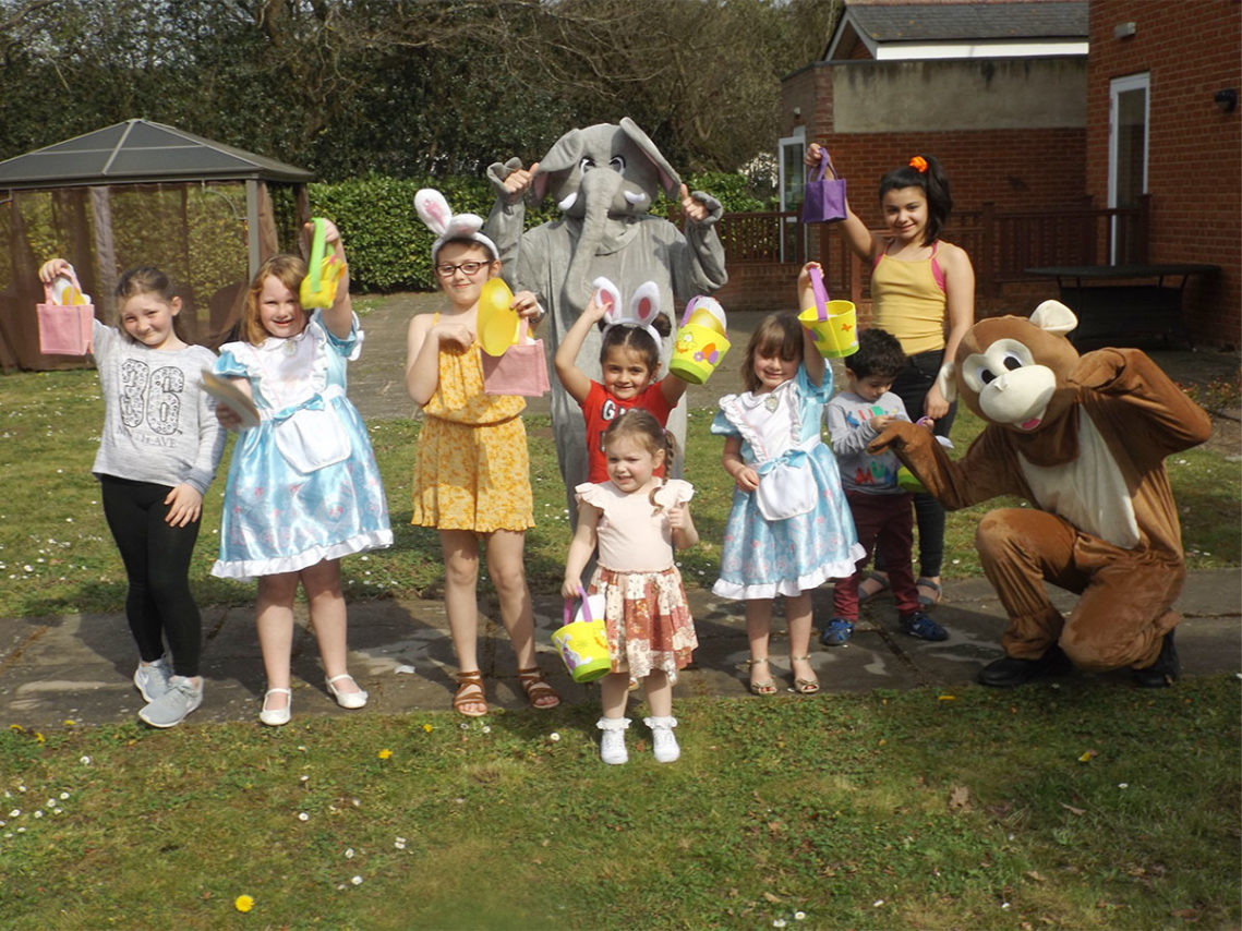 A group of children enjoying an Easter egg hunt in the garden at Princess Christian Care Home