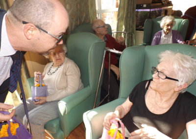 Man handing a flower gift to a lady resident at Princess Christian Care Home