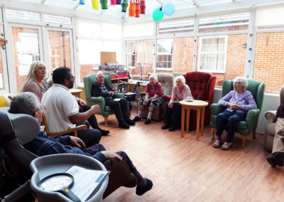 Residents and physiotherapist sharing a musical gym session in the conservatory at Princess Christian Care Home