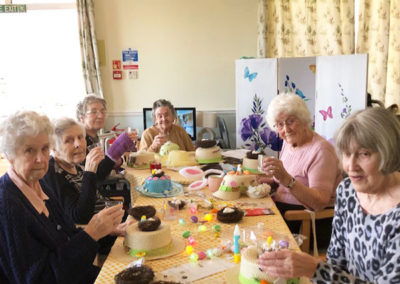 Lady residents around a table making Easter bonnets