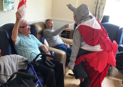 Staff member dressed as St George and the dragon entertaining residents