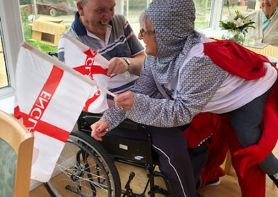 Staff member dressed as St George and the dragon making a resident smile