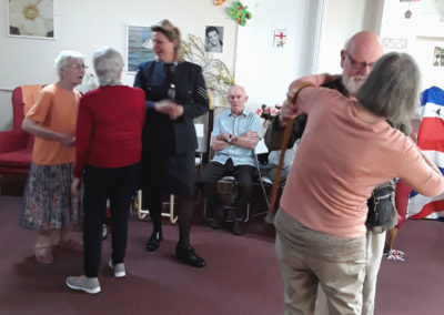 Residents at Lulworth House Residential Care Home dancing together in their lounge to live music