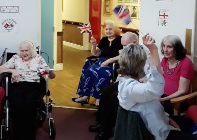Residents sitting together listening to live music and waving Union Jack flags