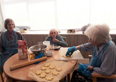 Lady residents around a table cutting out shortbread biscuits