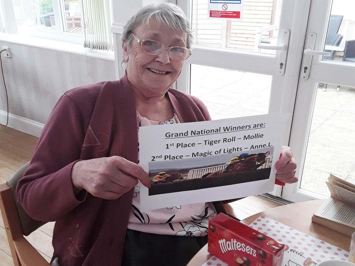 Lady resident at Woodstock Residential Care Home with her Grand National chocolate prize