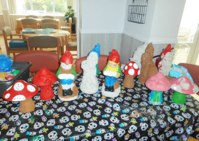 A collection of hand painted pottery gnomes and toadstools for the garden