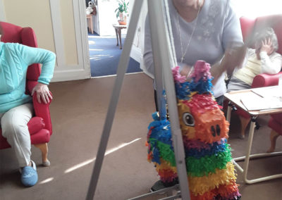 Resident hitting a colourful piñata