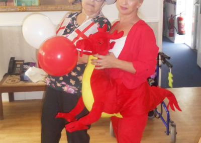 Staff dressed for St George's Day in a dragon costume and English flags