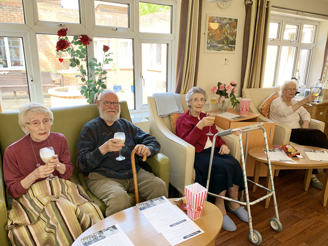 A group of Woodstock residents sitting together enjoying pub drinks and snacks in their lounge