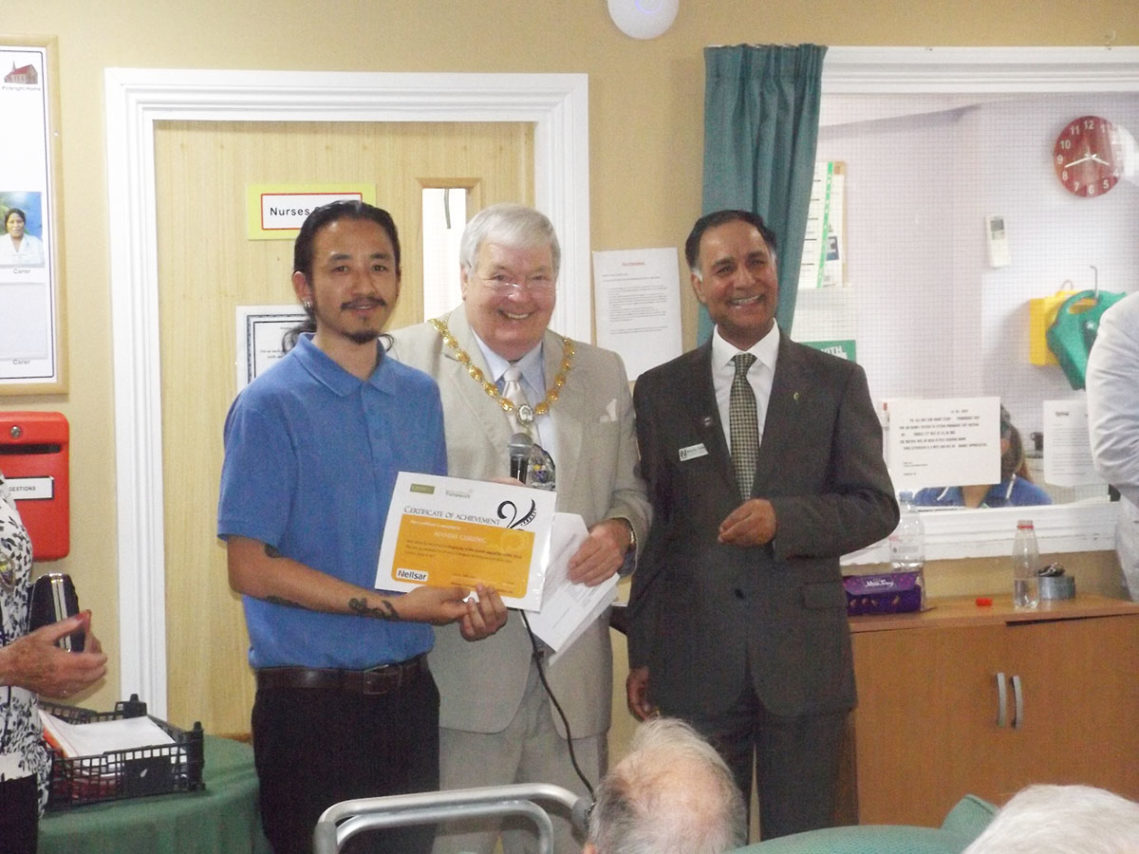 Staff member receiving a recognition certificate from Princess Christian Home Manager and the Mayor of Surrey Heath