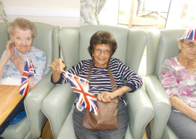 Lady residents at Sonya Lodge waving a Union Jack flags