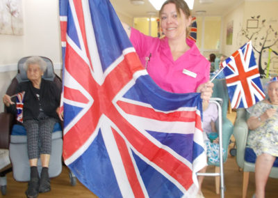 Staff member at Sonya Lodge waving a large Union Jack flag