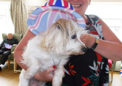 Staff member with a dog wearing a Union Jack hat