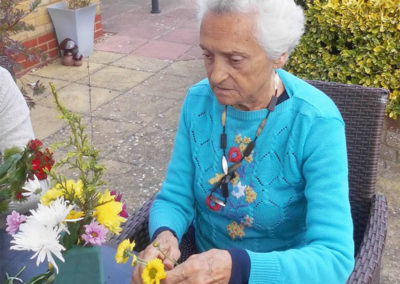 Woodstock resident arranging flowers at a table outside in the garden
