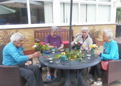 Woodstock ladies flower arranging at a table outside in the garden