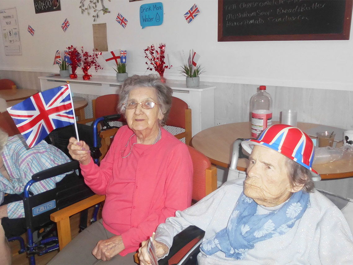 Two Woodstock ladies, one waving a Union Jack flag and the other wearing a Union Jack hat