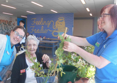 Residents and staff tending plants at the Oasis Dementia Cafe