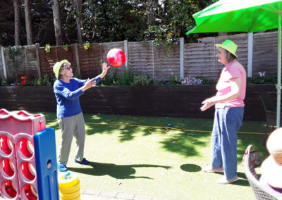 Residents playing with a ball in the garden at Lulworth House Residential Care Home