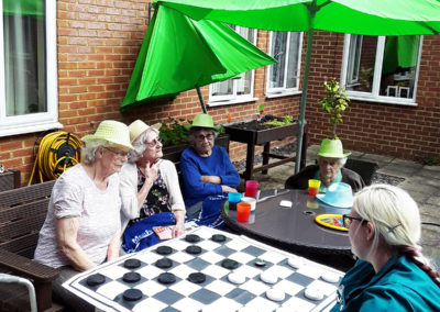 Residents playing a large games of draughts in the garden at Lulworth House