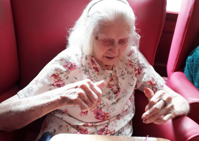 Lady resident enjoying sensory crafts at Lulworth House Residential Care Home