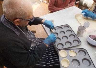 Resident putting tart pastry into trays
