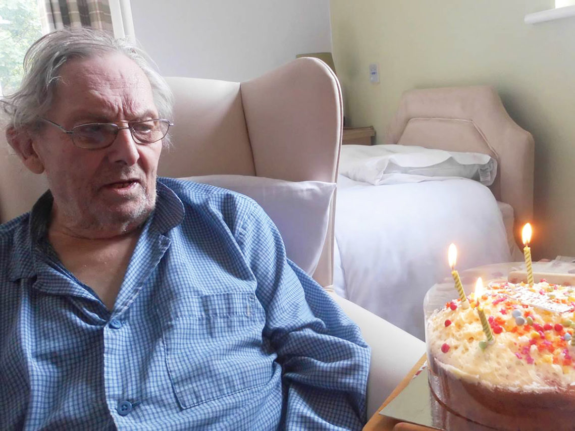 Male resident receiving his birthday cake with candles