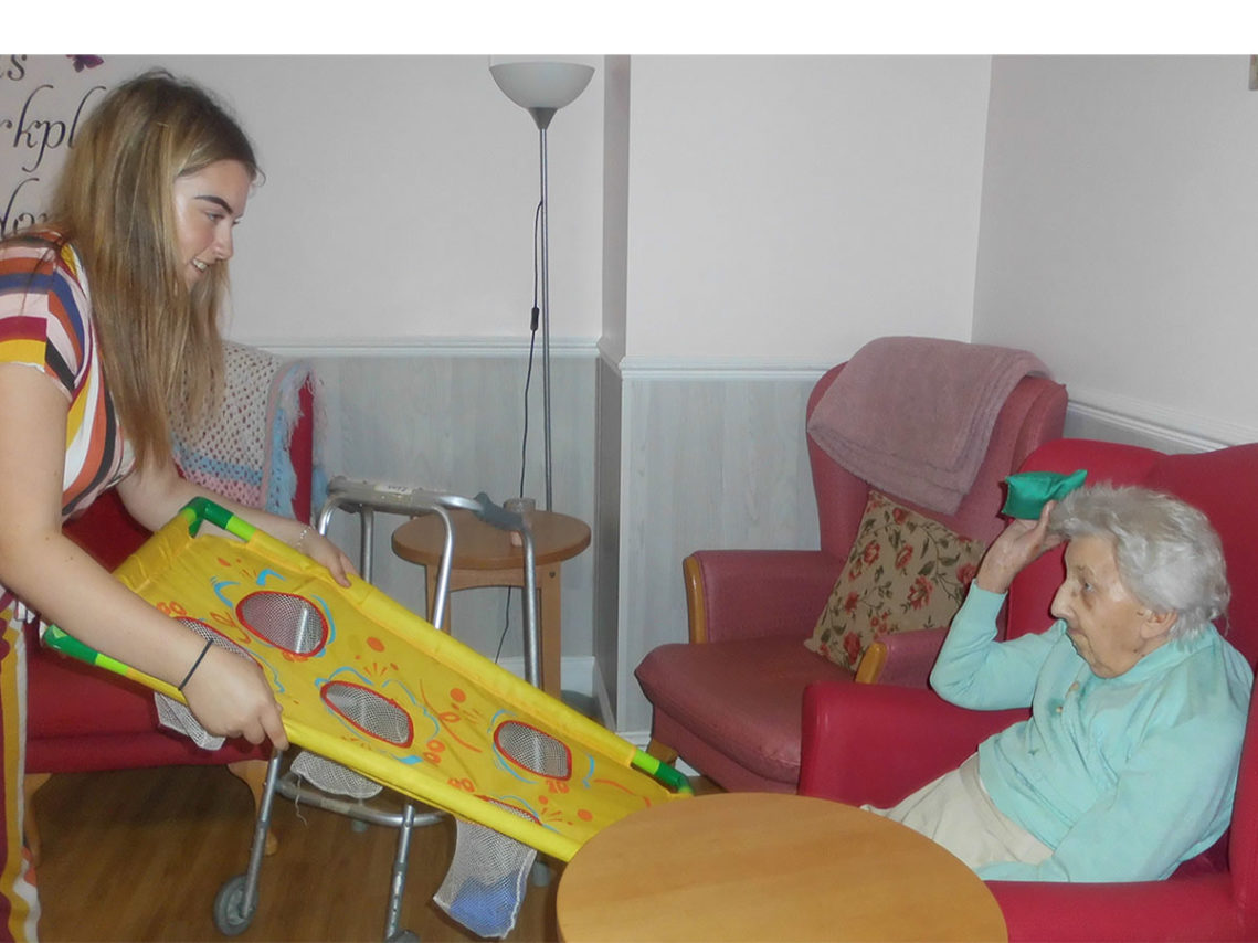 Princes Trust volunteer with a lady resident playing a target games with a beanbag