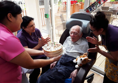 Male resident being presented with his birthday cake by staff