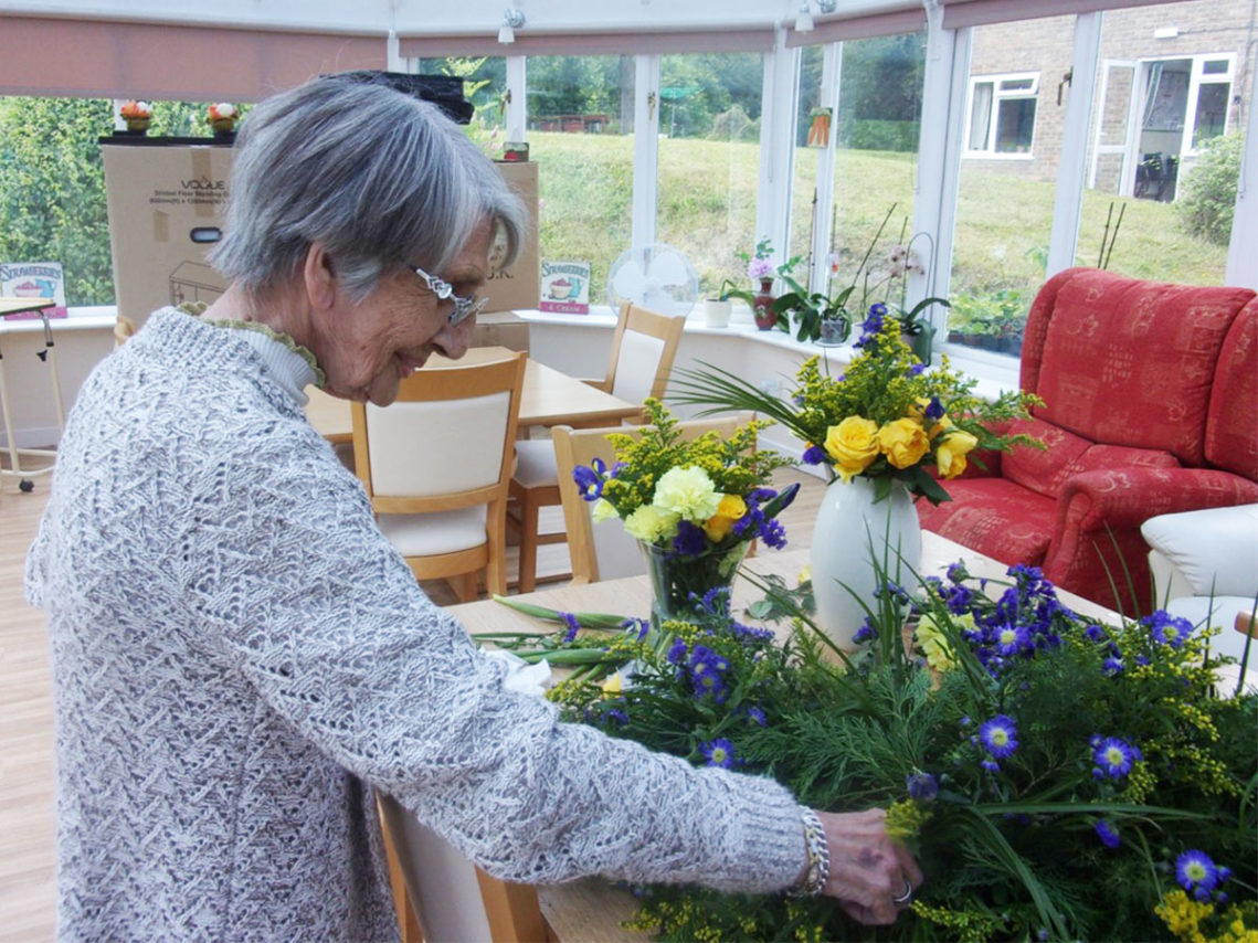 Lady resident arranging flowers at Loose Valley Care Home