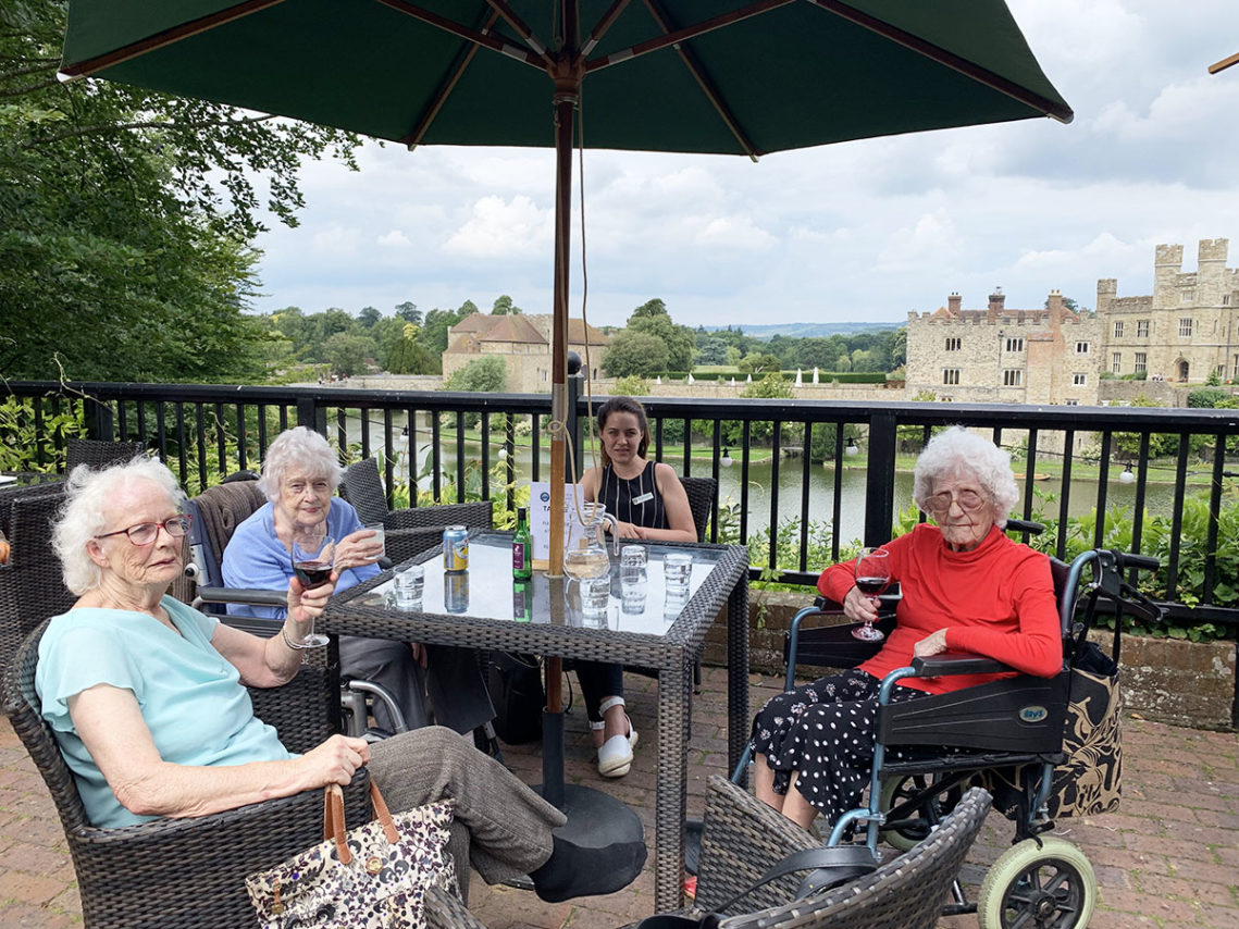 Lady residents from Lulworth House enjoying a glass of wine outside at Leeds Castle