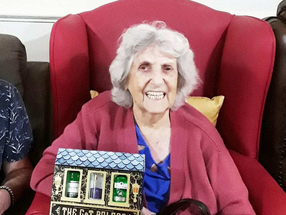 Lady resident with a G&T set won on a raffle at Lulworth House