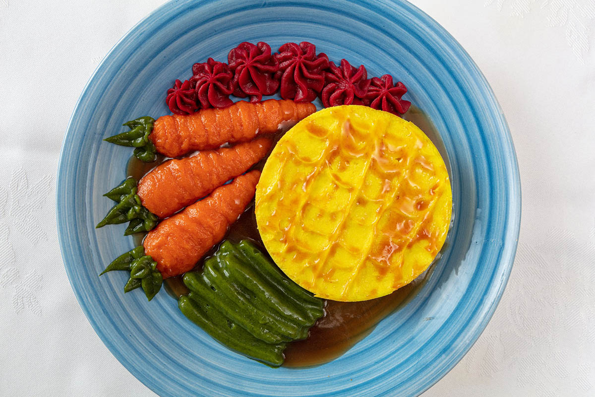 A puréed cottage pie with carrots, beans and red cabbage
