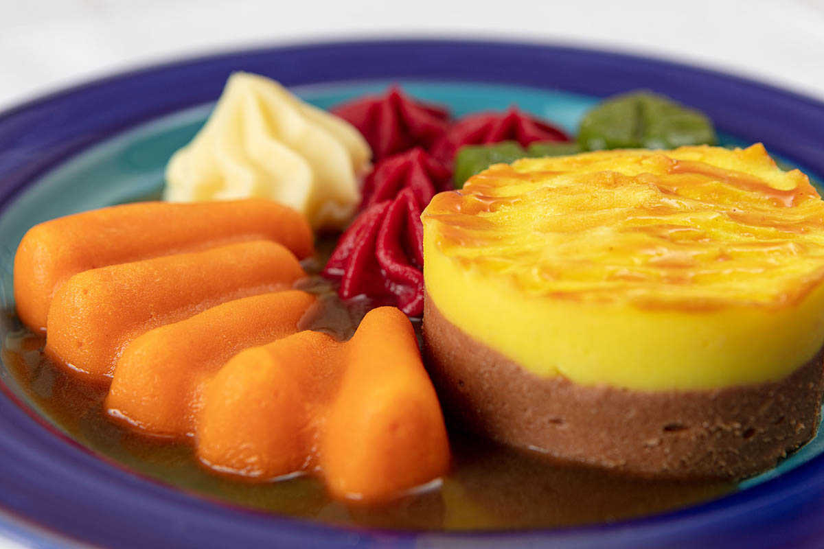 A puréed shepherd’s pie with carrots, mash and red and green cabbage