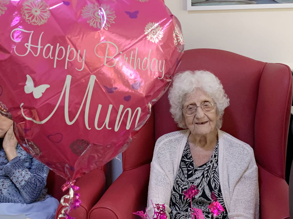 Lady resident with a heart shaped birthday balloon